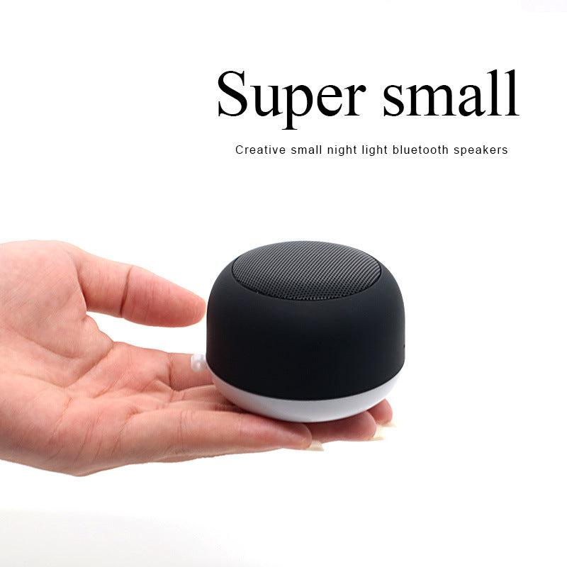 Wireless Bluetooth mini speaker, black cylindrical with textured speaker grille top