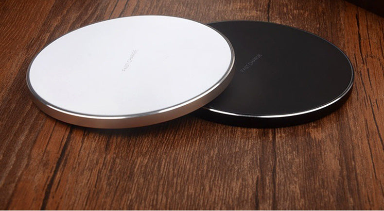 Wireless charger pad set: white disc and dark disc on a wooden surface