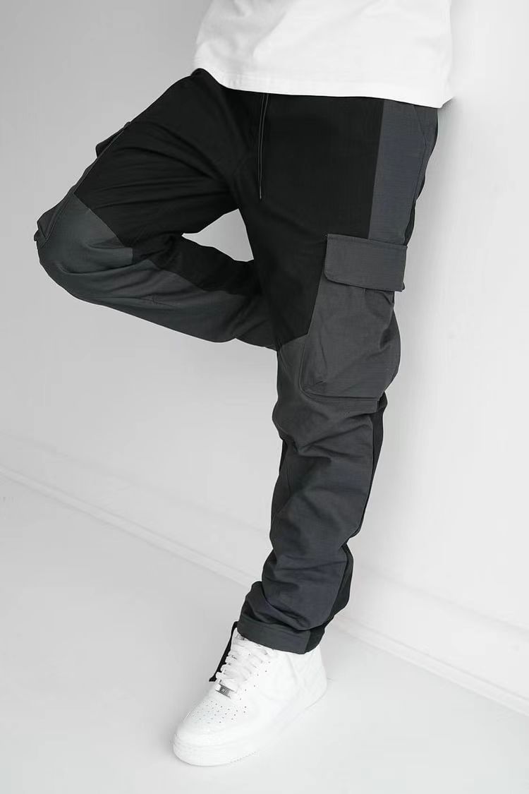Black cargo trousers with thigh pocket flap detail, relaxed fit, cuffed ankles