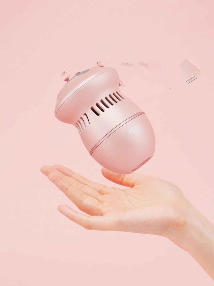 Beige electric foot file grinder device held above a hand