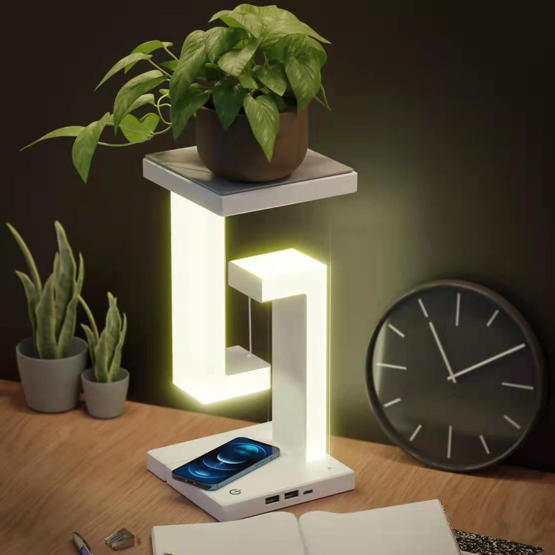 White wireless charging balance table lamp with glowing L-shaped light frame and phone base