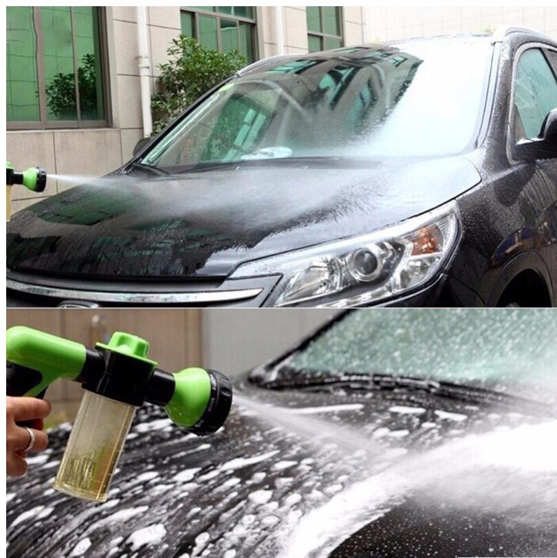 Green and black pressure foam spray gun spraying foam onto a car hood