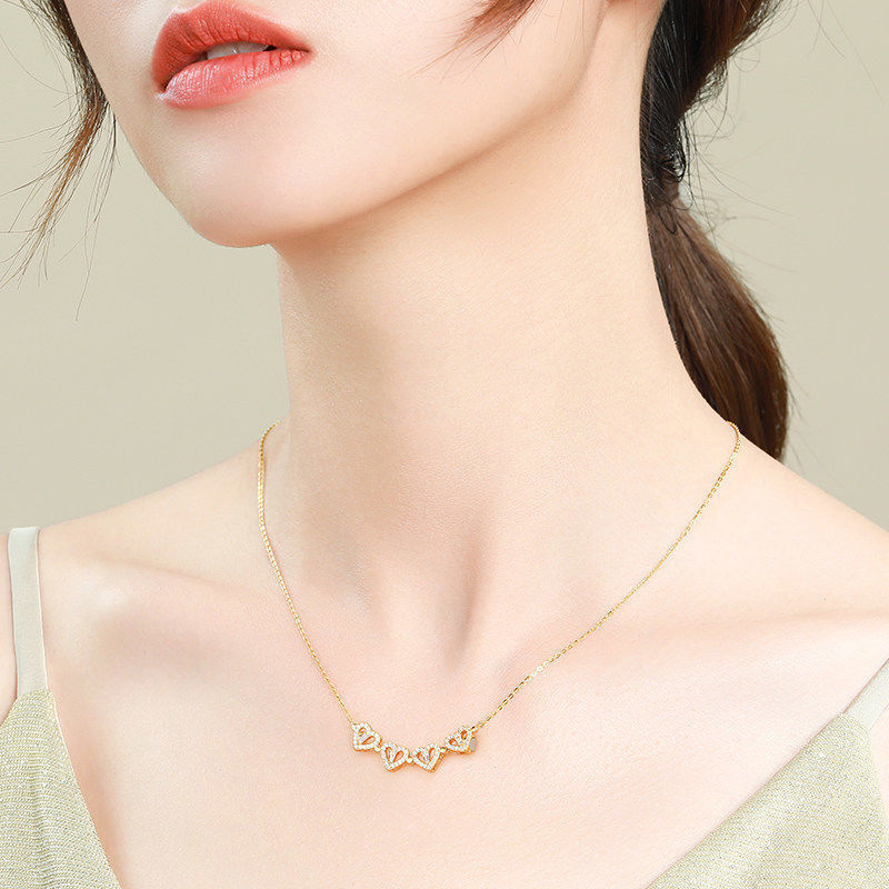 Four-leaf clover pendant necklace in gold-tone worn at the collarbone