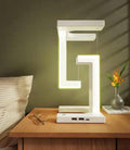 White wireless charging table lamp with glowing outline frame and phone charging dock