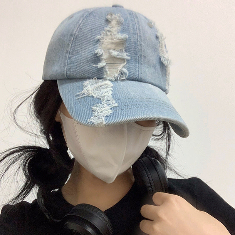 Light blue denim baseball cap with distressed, ripped front panels
