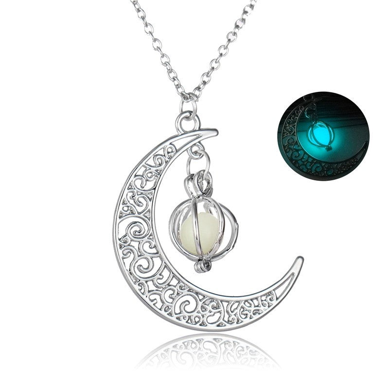 Silver crescent moon charm necklace with glowing teal stone on a chain