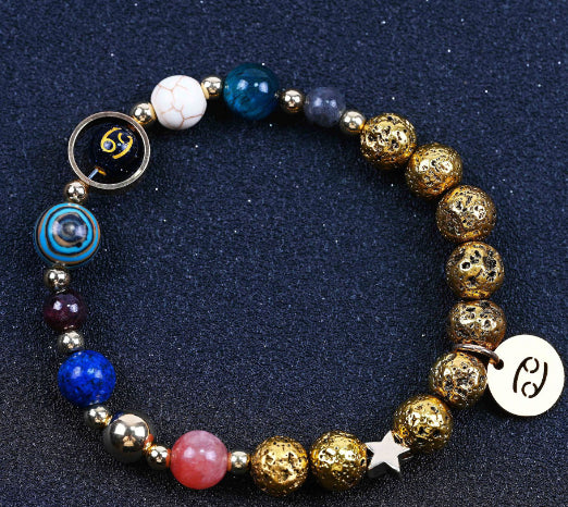 Beaded bracelet with gold beads, blue and pink stones, and zodiac charm accents