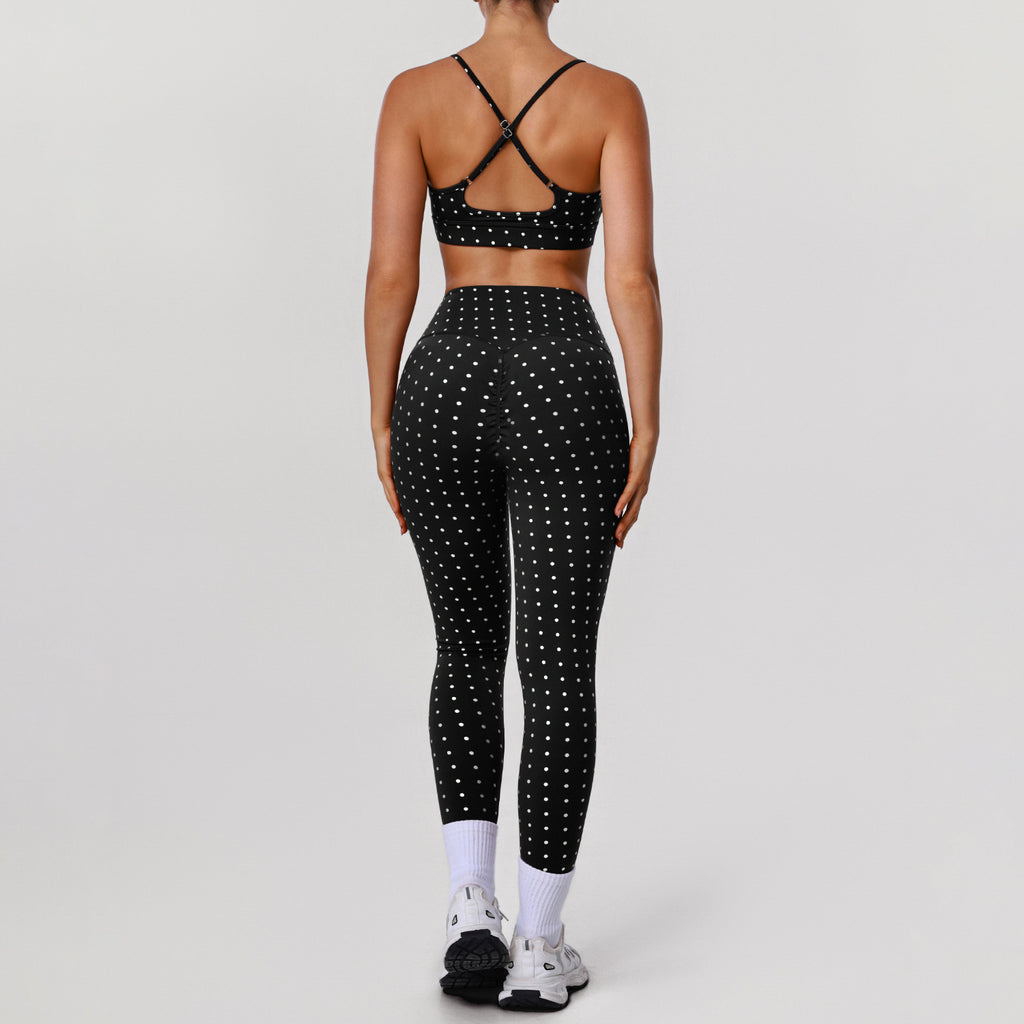 Women’s black sports bra and workout pants set with white dot print, crisscross back